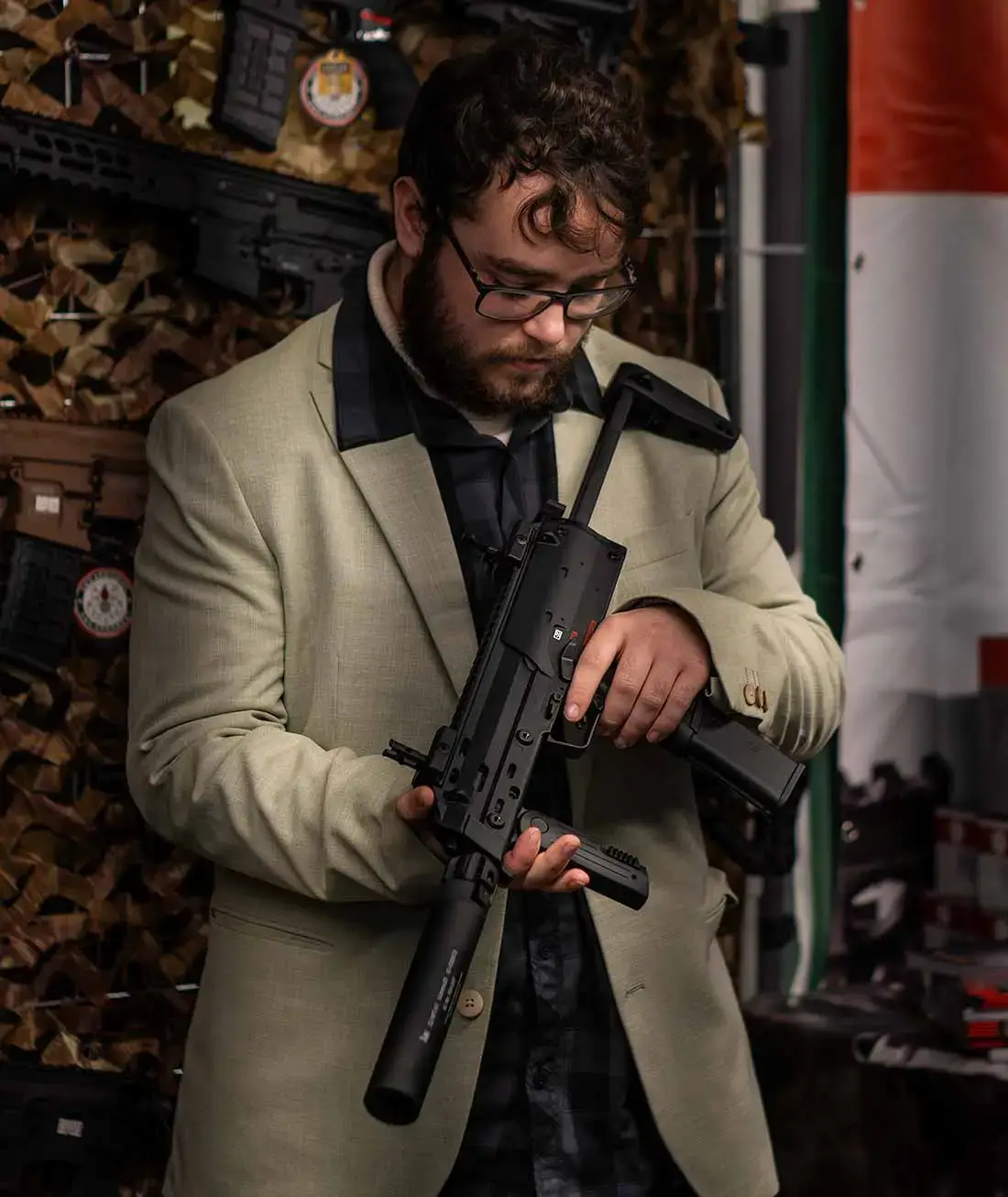 Ein Mann im Anzug hält eine Airsoft-Maschinenpistole in den Händen